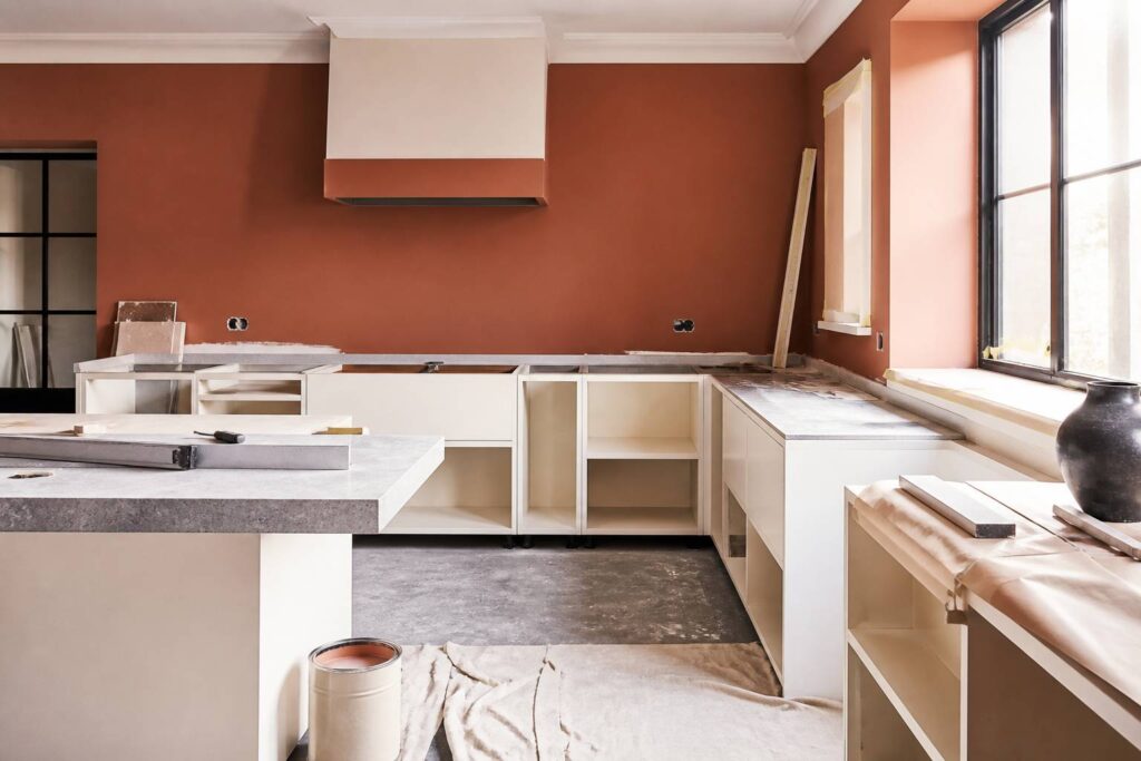 Cuisine en rénovation avec murs peints terracotta et meubles neufs
